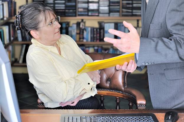 Old woman being talked down to by male coworker
